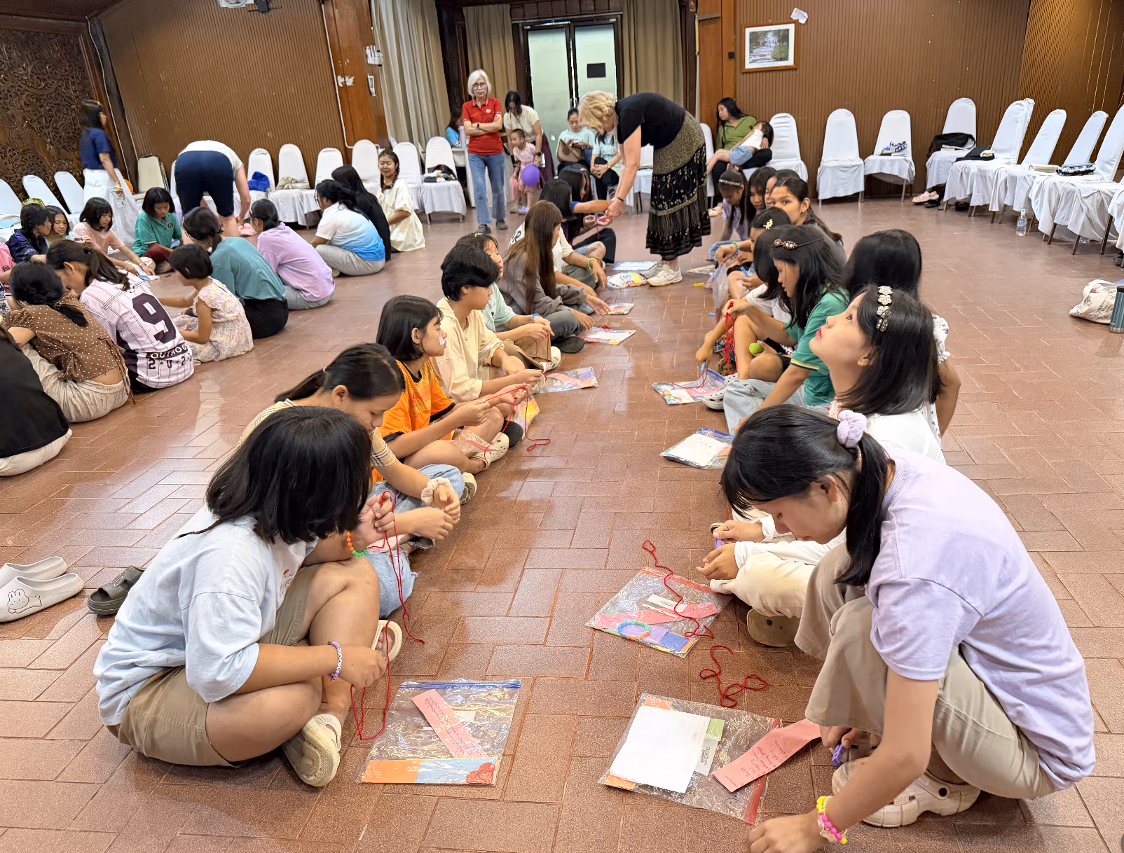 Girls curiously assembling their heart mobiles